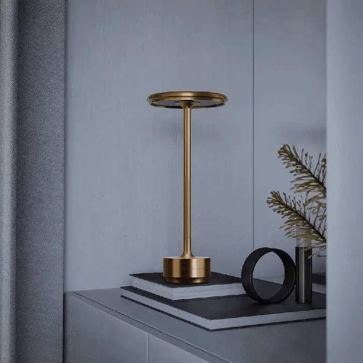 Gold lamp on a dark surface with a gray wall background